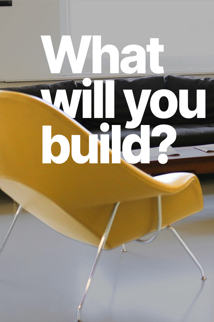 Two mustard womb chairs facing a charcoal sofa and a low wooden table